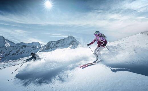Freerider skiing in deep snow on the Kitzsteinhorn in bright sunshine
