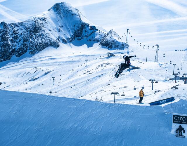 Snowboarder springt über Schanze im Skigebirge