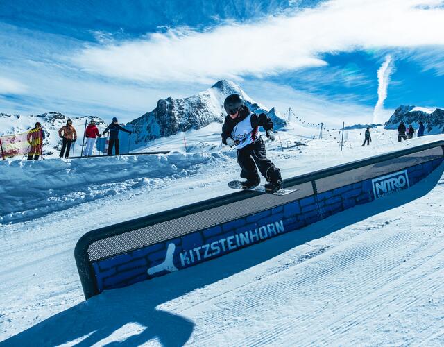 Snowboarder auf Rail im Snowpark