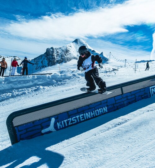 Snowboarder auf Rail im Snowpark