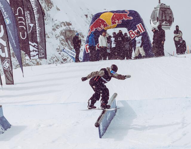 Snowboarder auf Rail im verschneiten Snowpark