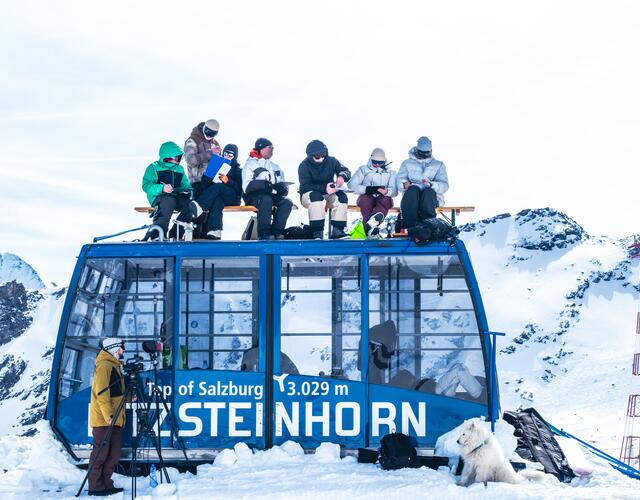 Skifahrergruppe auf Gondeldach im Hochgebirge