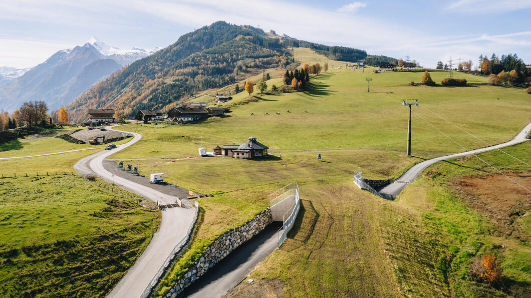 Straßenunterführung am Maiskogel mit Bergpanorama und grüner Wiese im Sommer