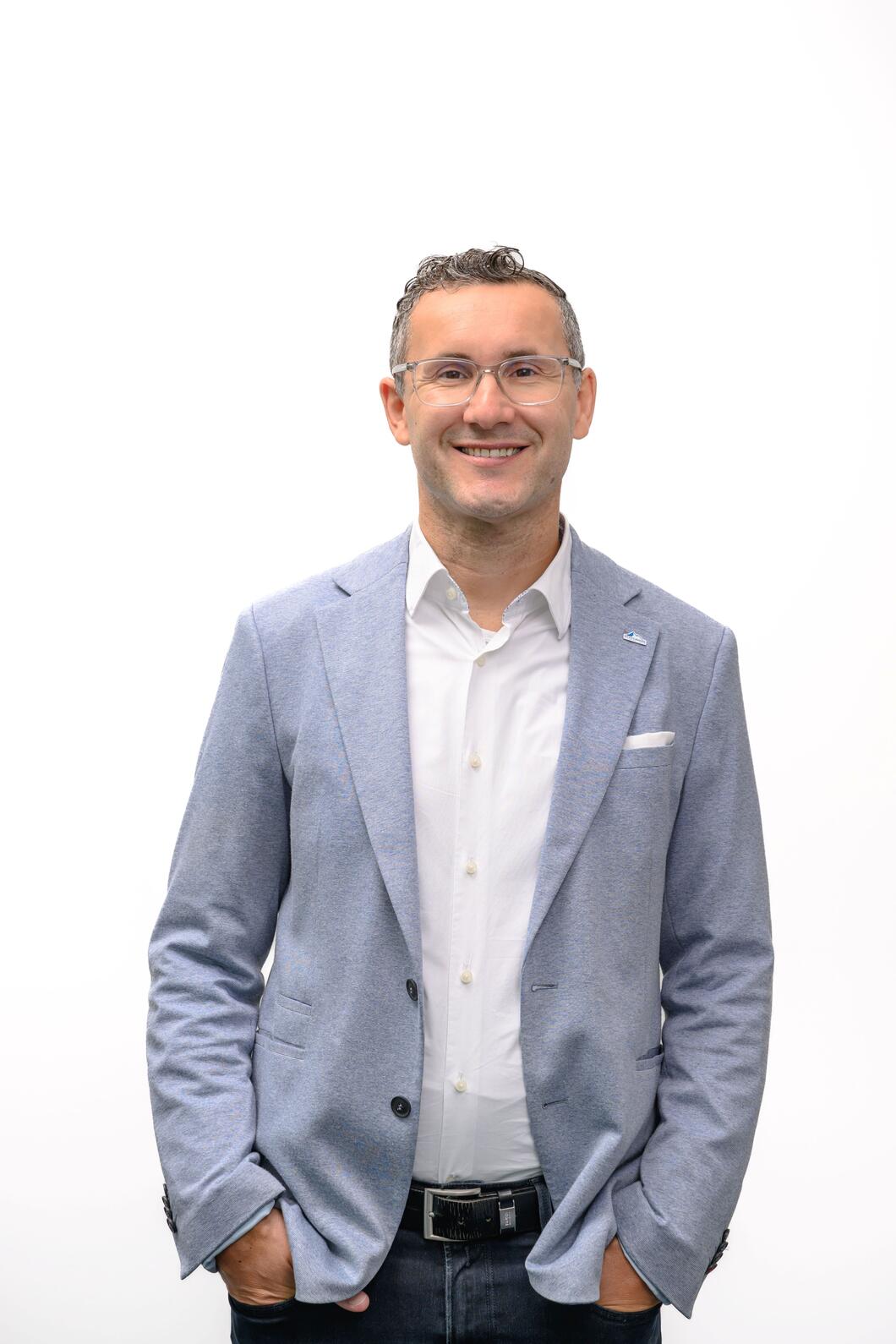 Vorstandsdirektor der Gletscherbahnen Kaprun AG Thomas Maierhofer in hellem Sakko und weißem Hemd lächelt