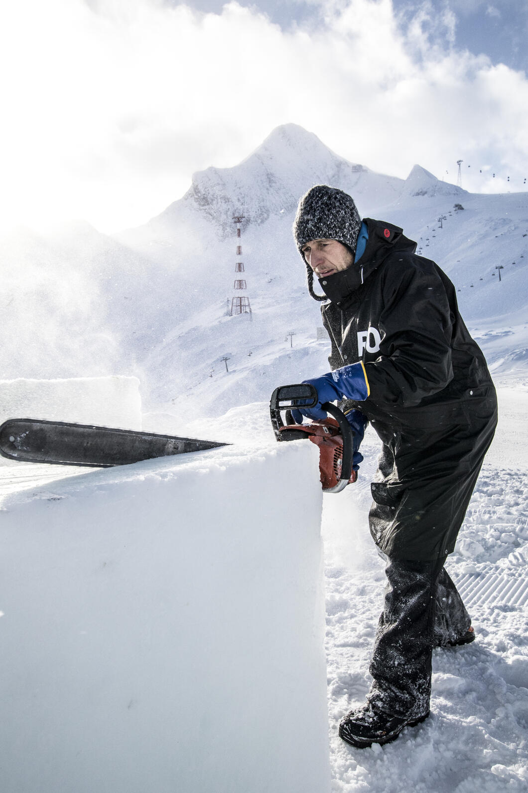 Kitzsteinhorn ICE CAMP presented by Audi_Max Seibald | © Kitzsteinhorn / Dominik Wartbichler Mit der Motorsäge bearbeitet der Künstler und Bildhauer Max Seibald die Eisblöcke für seine ICE CAMP-Skulpturen. Er ist seit dem ersten ICE CAMP im Winter 2006/2007 mit dabei. | © Kitzsteinhorn / Dominik Wartbichler