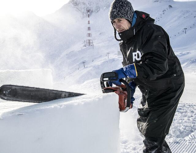 Mit der Motorsäge bearbeitet der Künstler und Bildhauer Max Seibald die Eisblöcke für seine ICE CAMP-Skulpturen. Er ist seit dem ersten ICE CAMP im Winter 2006/2007 mit dabei. | © Kitzsteinhorn / Dominik Wartbichler