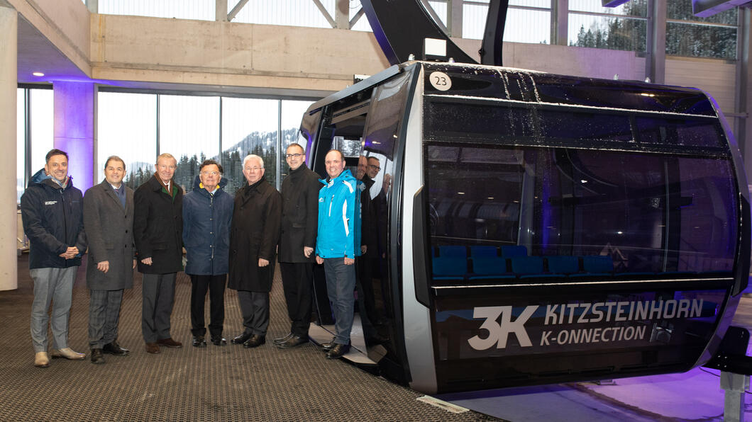Bei der Eröffnung 3K K-onnection Gruppe von Männern vor einer modernen Gondel der 3K K-onnection am Kitzsteinhorn