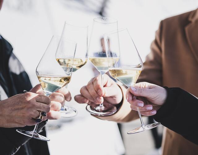Four hands clink champagne glasses | © Stefanie Oberhauser