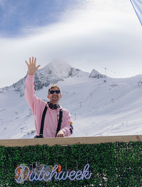 DJ winkt vor schneebedeckten Bergen bei Dutchweek