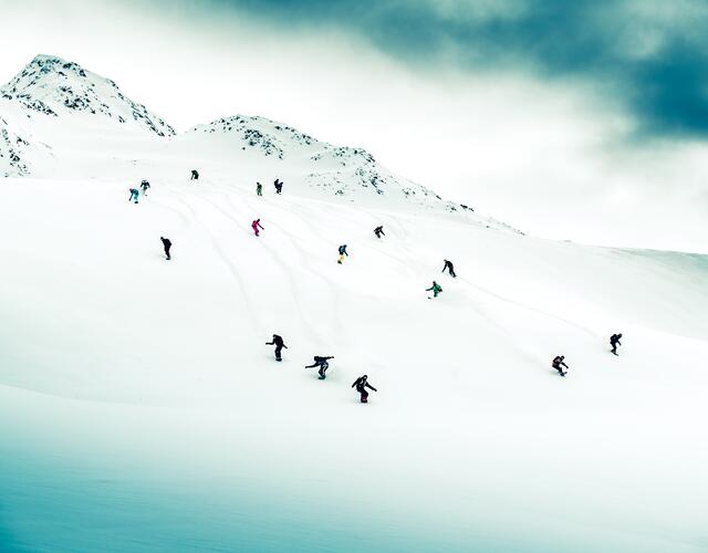 Numerous snowboarders on snowy mountain slope