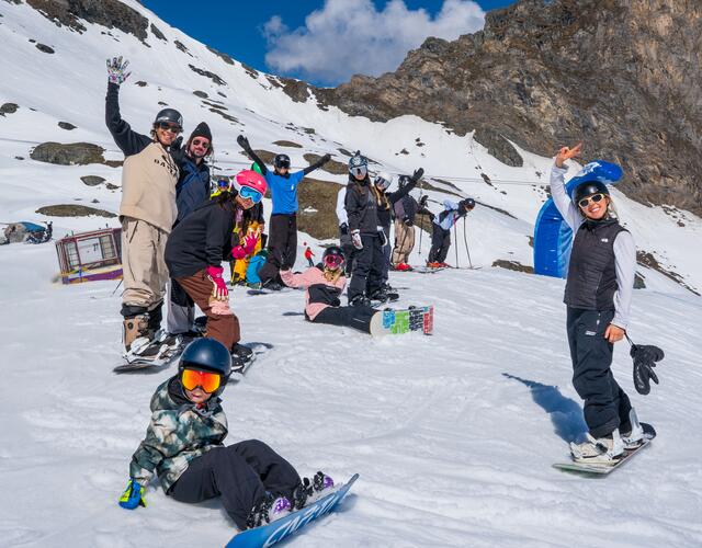 Fröhliche Snowboarder-Gruppe auf verschneitem Berg