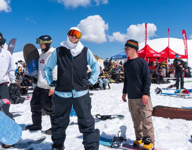 Gruppe von Snowboardern auf sonnigem Berg im Schnee