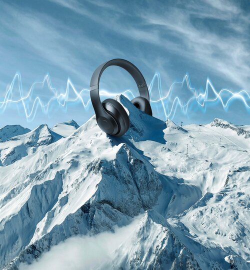 Kopfhörer auf schneebedecktem Berggipfel, blaue Schallwellen am Himmel. | © Kitzsteinhorn 