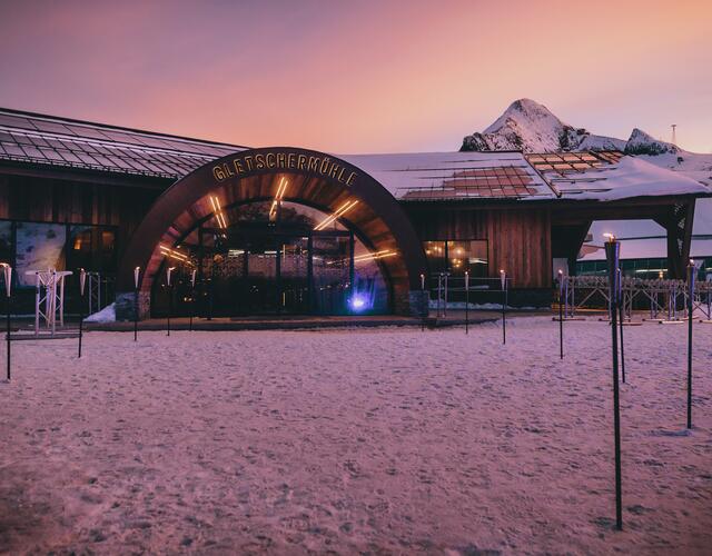 Beleuchtete Gletschermühle im Schnee bei Dämmerung