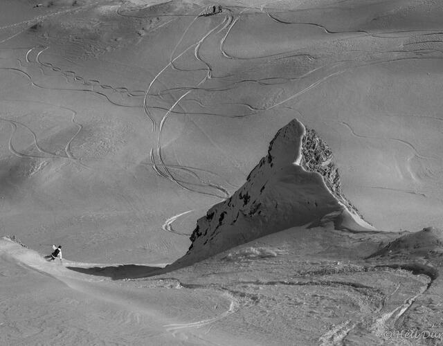Black and white photo of a mountain with ski tracks in the snow