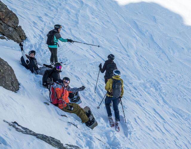 Risk'n'fun Freeride Campat the Kitzsteinhorn  | © Heli Fotoguide Snowboarders and skiers take a break in the snow, two plan the next route while the others wave at the camera | © Heli Fotoguide