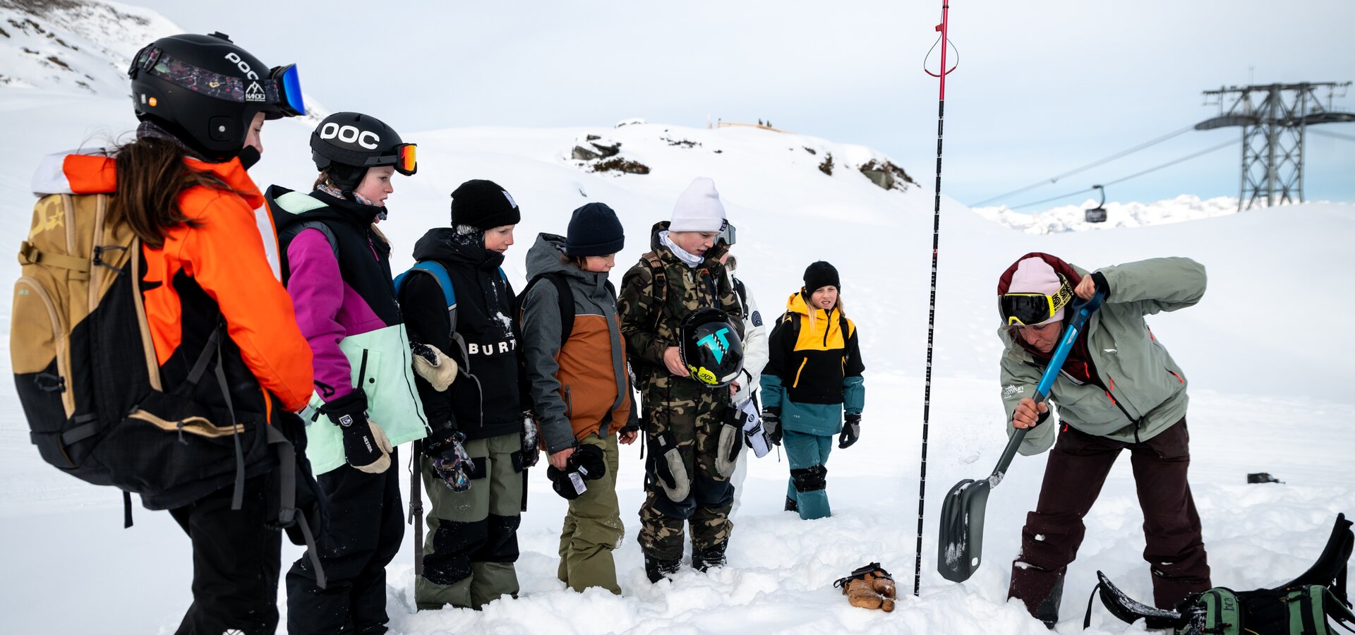 risk´n´fun NEXT LEVEL - FREERIDE CAMP am Kitzsteinhorn  | © Stef Scheitl Eine Gruppe von Kindern beim Risk’n’Fun Next Level Freeride Camp am Kitzsteinhorn, der Trainer zeigt mit der Schaufel, wie man im Ernstfall Menschen bei einer Lawine sucht | © Stef Scheitl