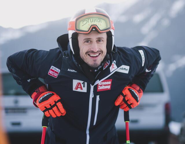 Lächelnder Skifahrer in voller Ausrüstung im Schnee