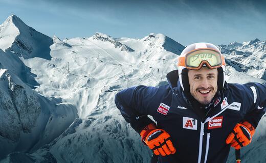 Lächelnder Skifahrer vor verschneiter Bergkulisse