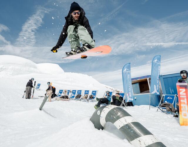 Flying snowboarder in the sunny snow park