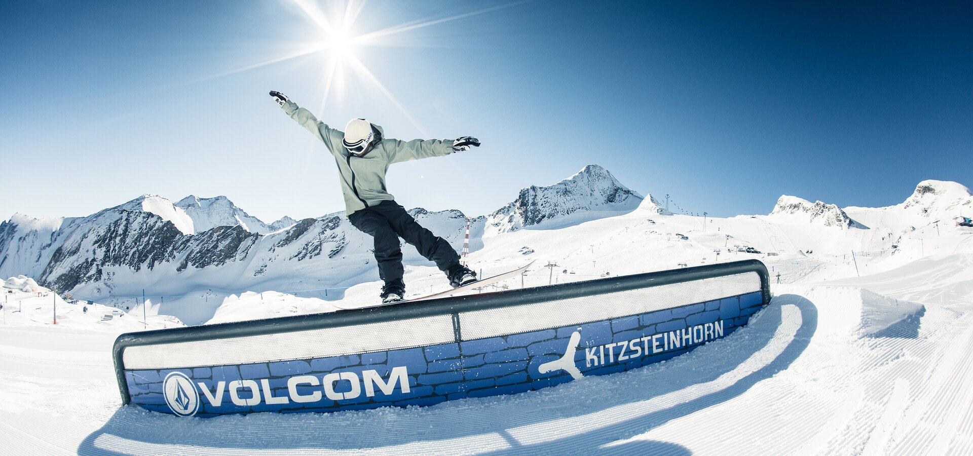 Snowboarder on rail in Snowpark Kitzsteinhorn in front of mountain panorama. | © Kitzsteinhorn / Markus Rohrbacher
