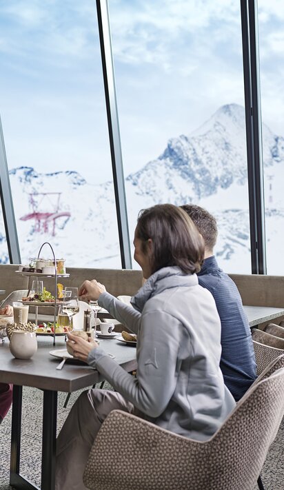 Vier Personen beim Essen vor Bergpanorama
