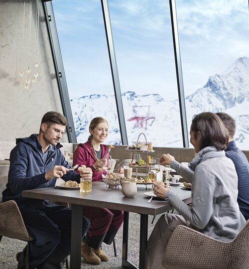 Vier Personen beim Essen vor Bergpanorama | © Kitzsteinhorn 