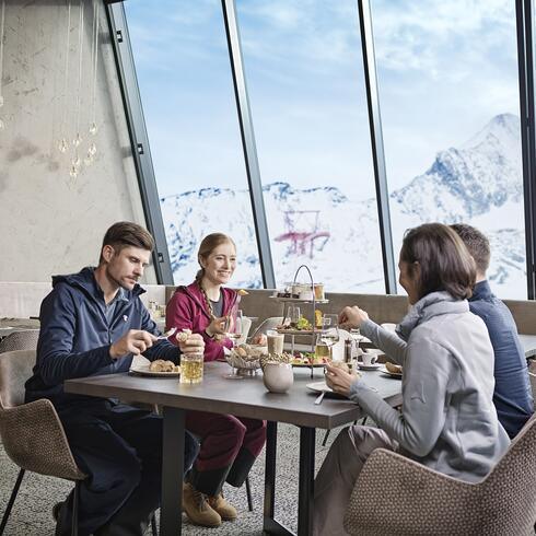 Vier Personen beim Essen vor Bergpanorama | © Kitzsteinhorn 
