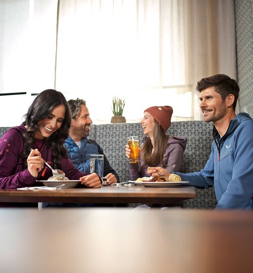 Four people sitting at a table eating at the Alpincenter Kitzsteinhorn