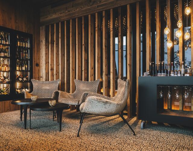 Cozy Alpine lounge with wine cabinet and armchairs