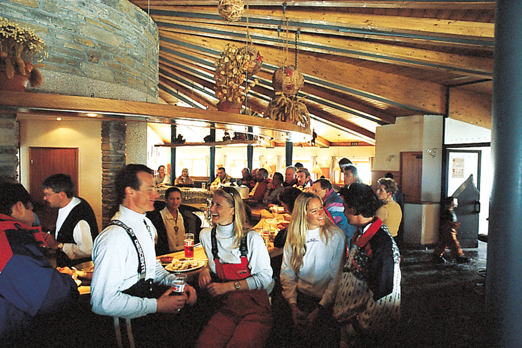 Interior view of a restaurant with guests at tables and a bar