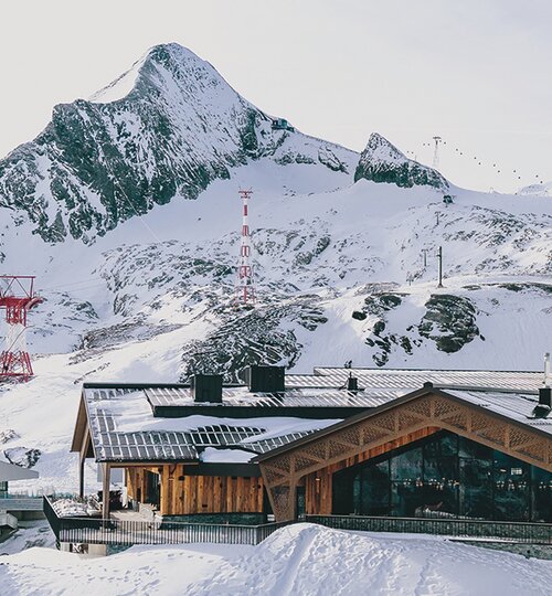 Modernes Holzgebäude in winterlicher Alpenlandschaft