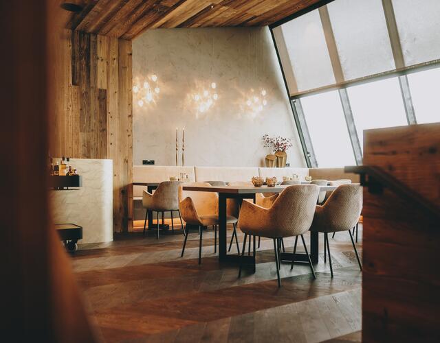 Modernes elegantes Restaurantinterieur mit Holzelementen und großen Fenstern