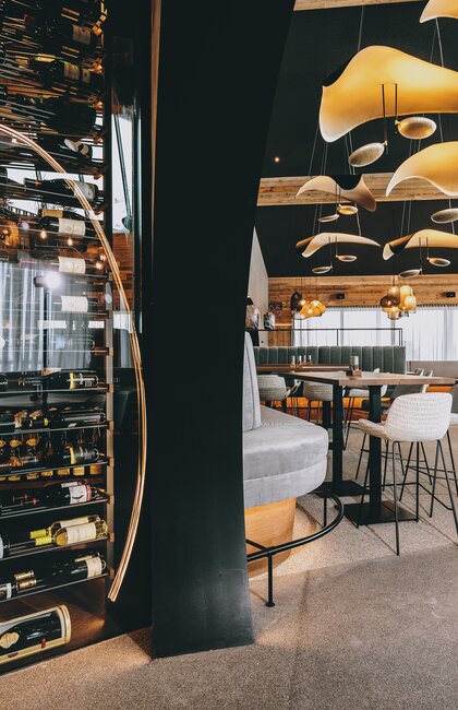 Modernes Restaurantinterieur mit großem Weinregal | © Kitzsteinhorn 