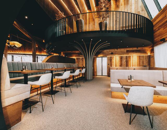 Modernes Restaurantinterieur mit Holzvertäfelung und Empore