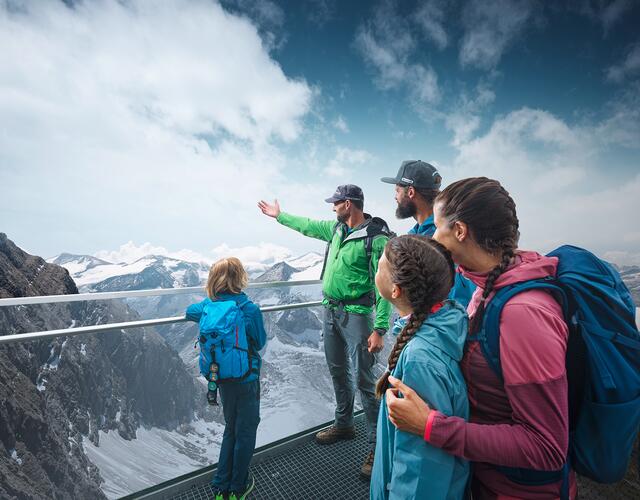 Family on observation deck overlooking snow-capped mountains and cloudy sky | © Kitzsteinhorn 
