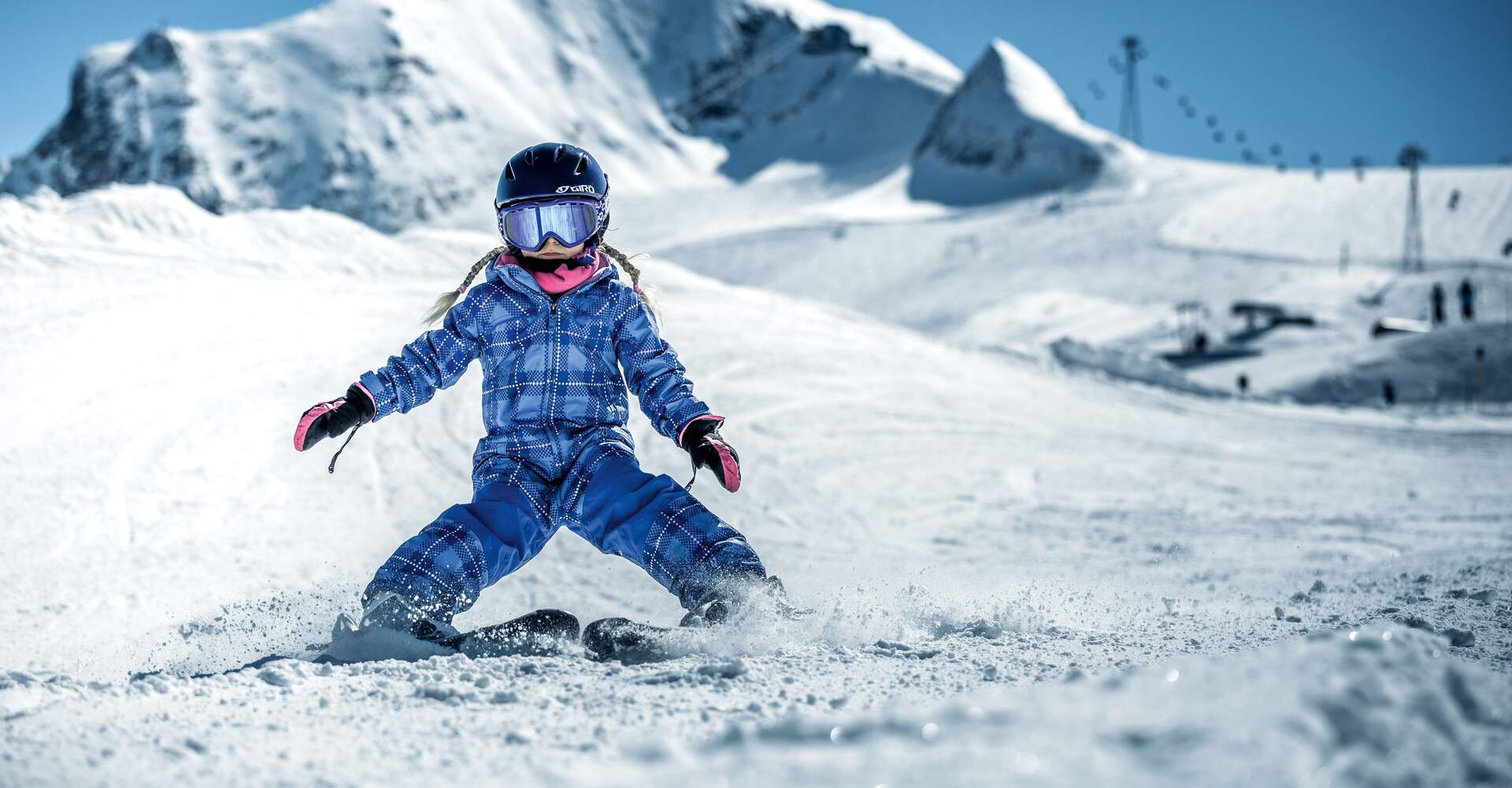 Kind fährt Ski vor schneebedecktem Berg am Kitzsteinhorn