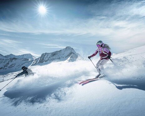 Freerider skiing in deep snow on the Kitzsteinhorn in bright sunshine