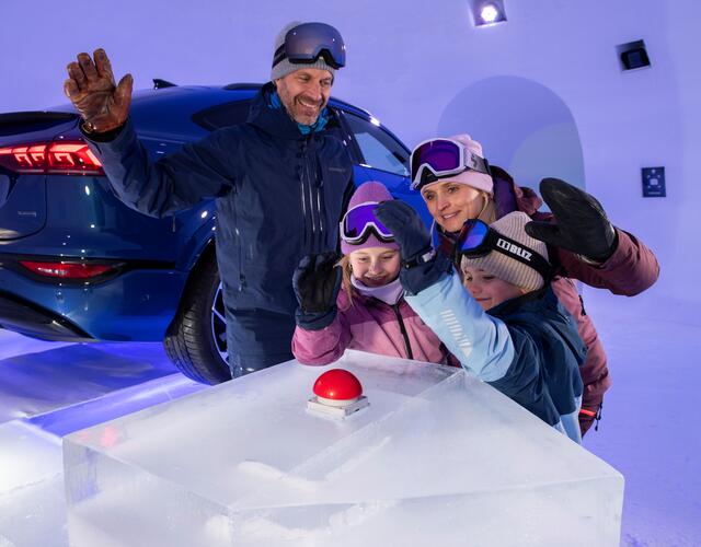Fröhliche Familie vor rotem Knopf auf Eisblock