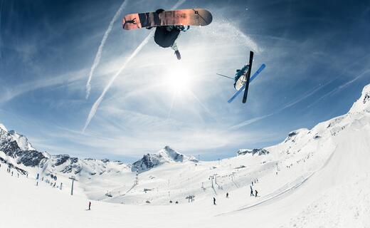 Ein Snowboarder und ein Skifahrer machen Tricks im Snowpark am Kitzsteinhorn | © Kitzsteinhorn / Rohrbacher